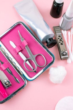 Manikür ve pedikür araçları pembe bir arka plan üzerinde