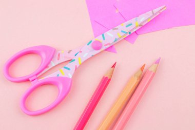 pembe makas, kalem ve pembe bir arka plan üzerinde yazılar