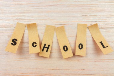 Kelime okulunun ahşap yüzeye yapıştırılmış çıkartmalarla çekilmiş yakın plan fotoğrafı.