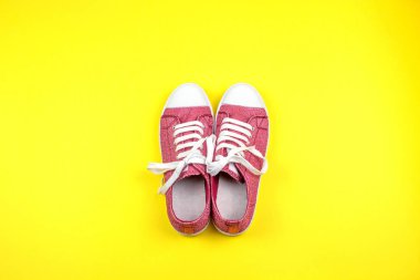 sarı arka planda canlı spor ayakkabı çifti 