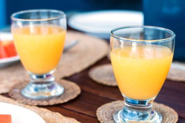 Kahvaltı için masaya portakal suyu bardakları.