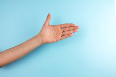 Mavi arka planda kadın eli hareketi.