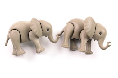 close-up shot of plastic toy elephants on white background