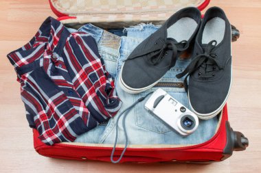 Kıyafetlerle dolu valiz görüntüsü yolculuk için hazır.