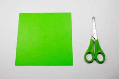 yeşil dekoratif kağıt ve üzerinde beyaz izole makas