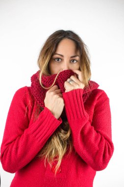 Beyaz üzerine izole edilmiş kırmızı kazak ve eşarp giyen güzel genç bir kadının portresi.