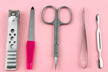Manikür ve pedikür araçları pembe bir arka plan üzerinde