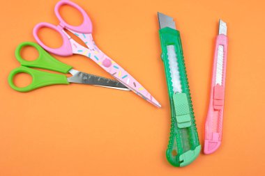 Renkli plastik kesiciler ve makas kağıt arka plan üzerinde