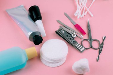 Manikür ve pedikür araçları pembe bir arka plan üzerinde
