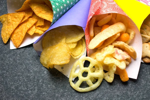 Muchos Tipos Snacks Conos Papel Sobre Mesa Rústica Oscura — Foto de Stock