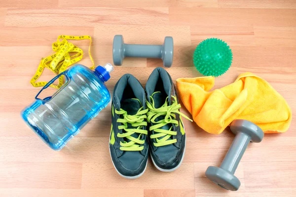 sport equipment, shoes and measuring tape on wooden background