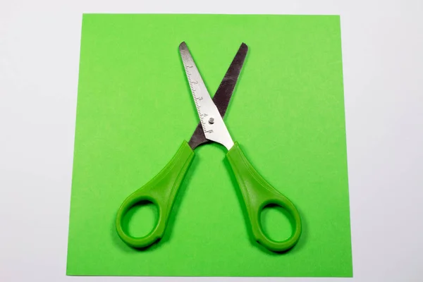 stock image green decorative paper and scissors isolated on white