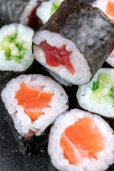 close up of sushi rolls with tuna, cucumber and salmon