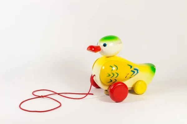 close-up shot of toy duck with wheels on white background