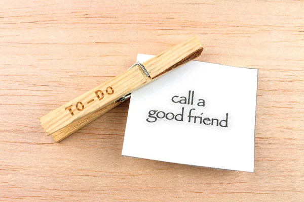 top view of to-do clothespin with call a good friend note on wooden background