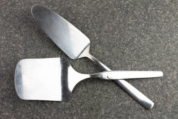 Zbliżenie Ujęcia Silver Spatulas Ciemnym Stole Rustykalnym — Zdjęcie stockowe