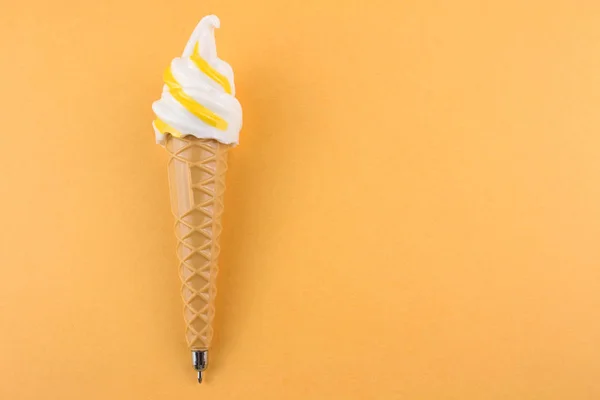 黄色い背景に氷のクリームの形をしたペンの上からの眺め — ストック写真
