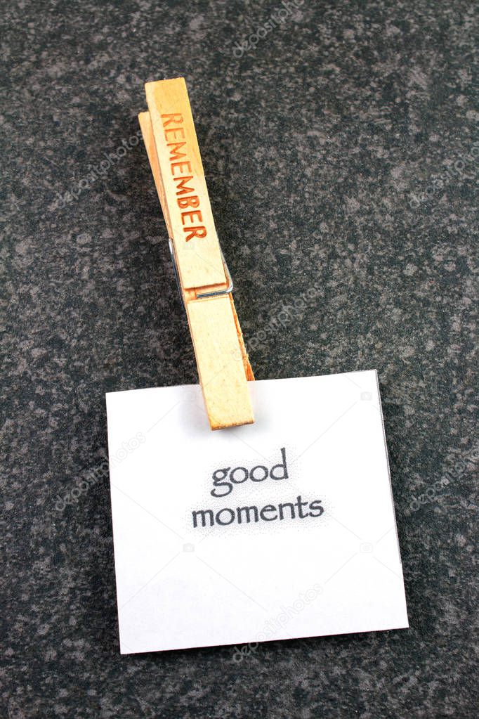 top view of wooden Remember clothespin with good moments note on dark background 