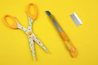 Sarı Plastik kesici, makas ve bıçak kağıt arka plan üzerinde