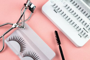 Pembe Arka Plan Üzerine Makyaj Yapışkanlı Kirpik Fişekleri ve Araçları