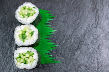 Üstten Görünüm suşi salatalık ile siyah taş masanın üzerine alır. 