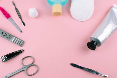 Manikür ve pedikür araçları pembe bir arka plan üzerinde