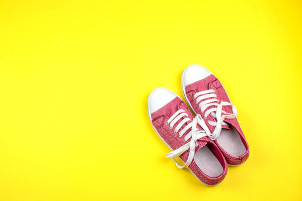 pair of vibrant sneakers on yellow background 