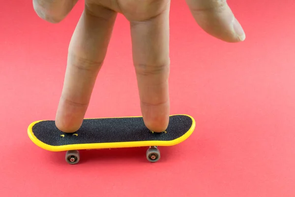 Muž Hraje Mini Skateboard Toy Růžovém Pozadí — Stock fotografie