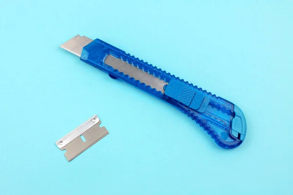 Blue Plastic Cutter and blade on Paper background