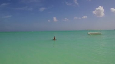 Bahamalar Adaları Eleuthera 'da yeşil deniz suyunda yıkanan bir kadın.