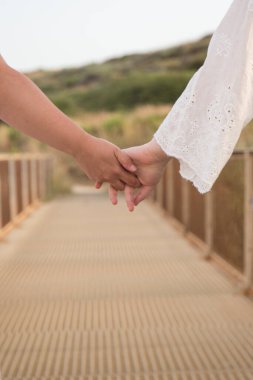 Kız arkadaşlar el ele tutuşurken sırt üstü yürürler.