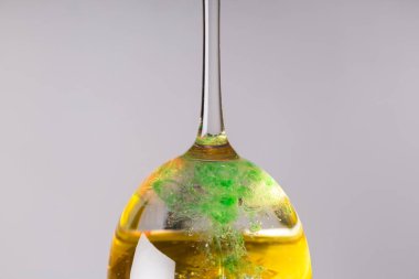 Tersine çevrilmiş bir bardakta, sarı yeşil ve beyaz renklerin karışımı