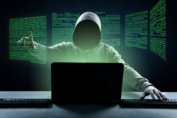 Хакер печатает код на клавиатуре ноутбука, чтобы проникнуть в киберпространство