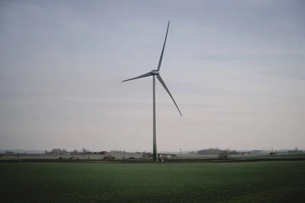 A single wind turbine stands tall above the flat farmlands of Skane, Sweden
