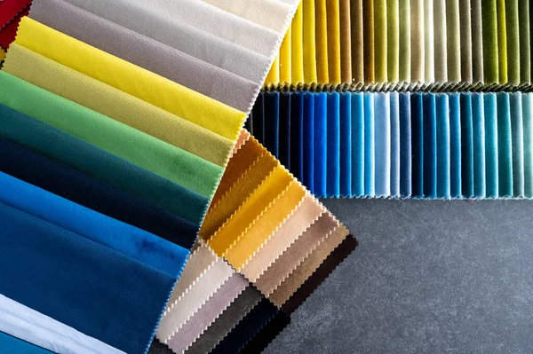 Çok renkli kadife kumaş örnekleri. Taş bir masanın üzerine yerleştirilmiş. Üzerinde fotokopi alanı var.