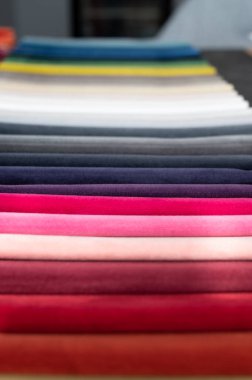 Katlanmış yumuşak, lüks kadife örnekleri masanın üstüne yerleştirilmiş.