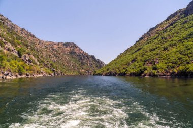 Yazın dağların arasında, İspanya ile Portekiz arasında bir nehirde turist gezisinde uyanmak.