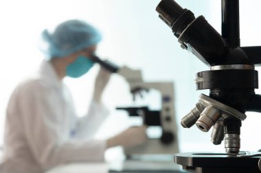 Modern mikroskop kullanarak, arka planda doktorla birlikte antik siyah mikroskop, seçici odak