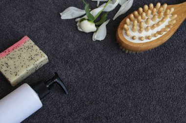 Spa evi. Masaj fırçası, sabun ve krem arka planda gri havlu