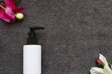 Spa evi. sabun ve tomurcuklar arka planda gri havluyla