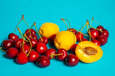 Mavi arka planda kayısı ve kiraz. Seçici odaklanma. Doğa
