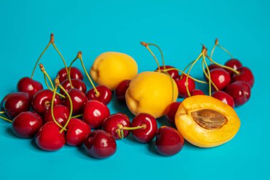 Mavi arka planda kayısı ve kiraz. Seçici odaklanma. Doğa