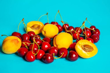 Mavi arka planda kayısı ve kiraz. Seçici odaklanma. Doğa