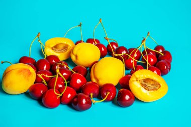 Mavi arka planda kayısı ve kiraz. Seçici odaklanma. Doğa