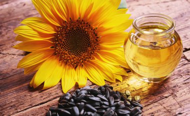 Eski ahşap arka planda ayçekirdeği ve yağ şişesi. Seçici odak