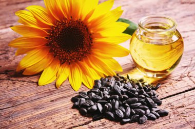 Eski ahşap arka planda ayçekirdeği ve yağ şişesi. Seçici odak