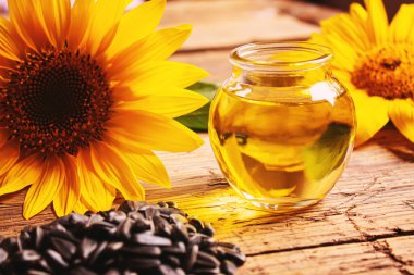 Eski ahşap arka planda ayçekirdeği ve yağ şişesi. Seçici odak