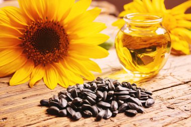 Eski ahşap arka planda ayçekirdeği ve yağ şişesi. Seçici odak