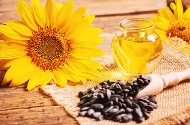 Eski ahşap arka planda ayçekirdeği ve yağ şişesi. Seçici odak