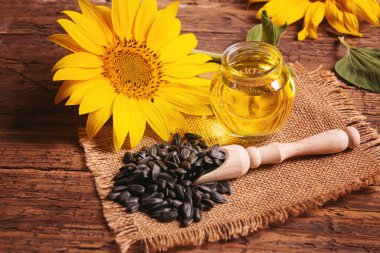 Eski ahşap arka planda ayçekirdeği ve yağ şişesi. Seçici odak